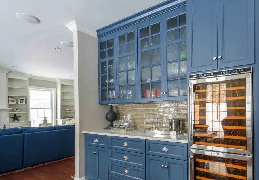 Custom kitchen with blue cabinetry and wine fridge